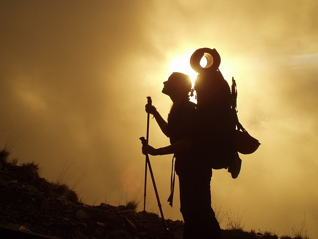 Backpacker silhouette climbing mountain